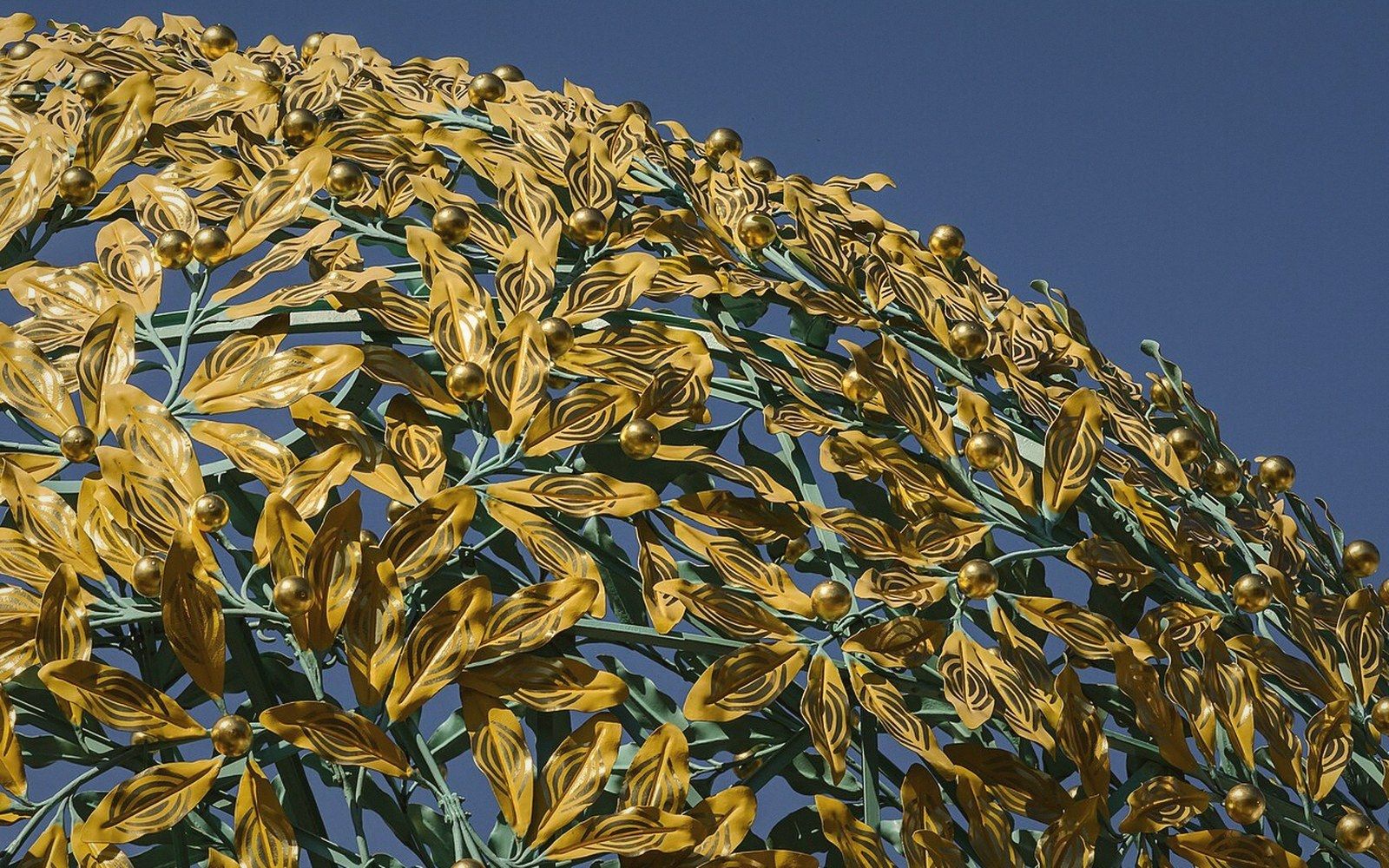 The gilded laurel-leaf dome of the Secession building seen from below against a pale sky